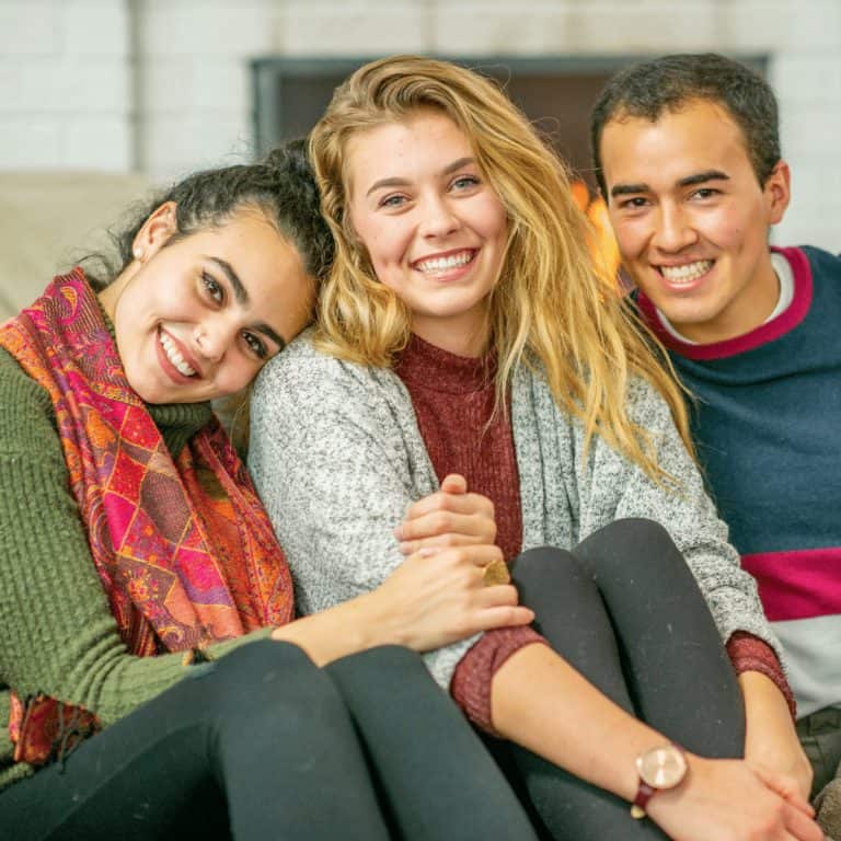 friends sitting on couch smiling